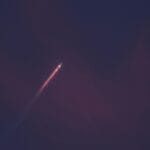 Rakieta nocą wznosząca się w górę z ognistym śladem