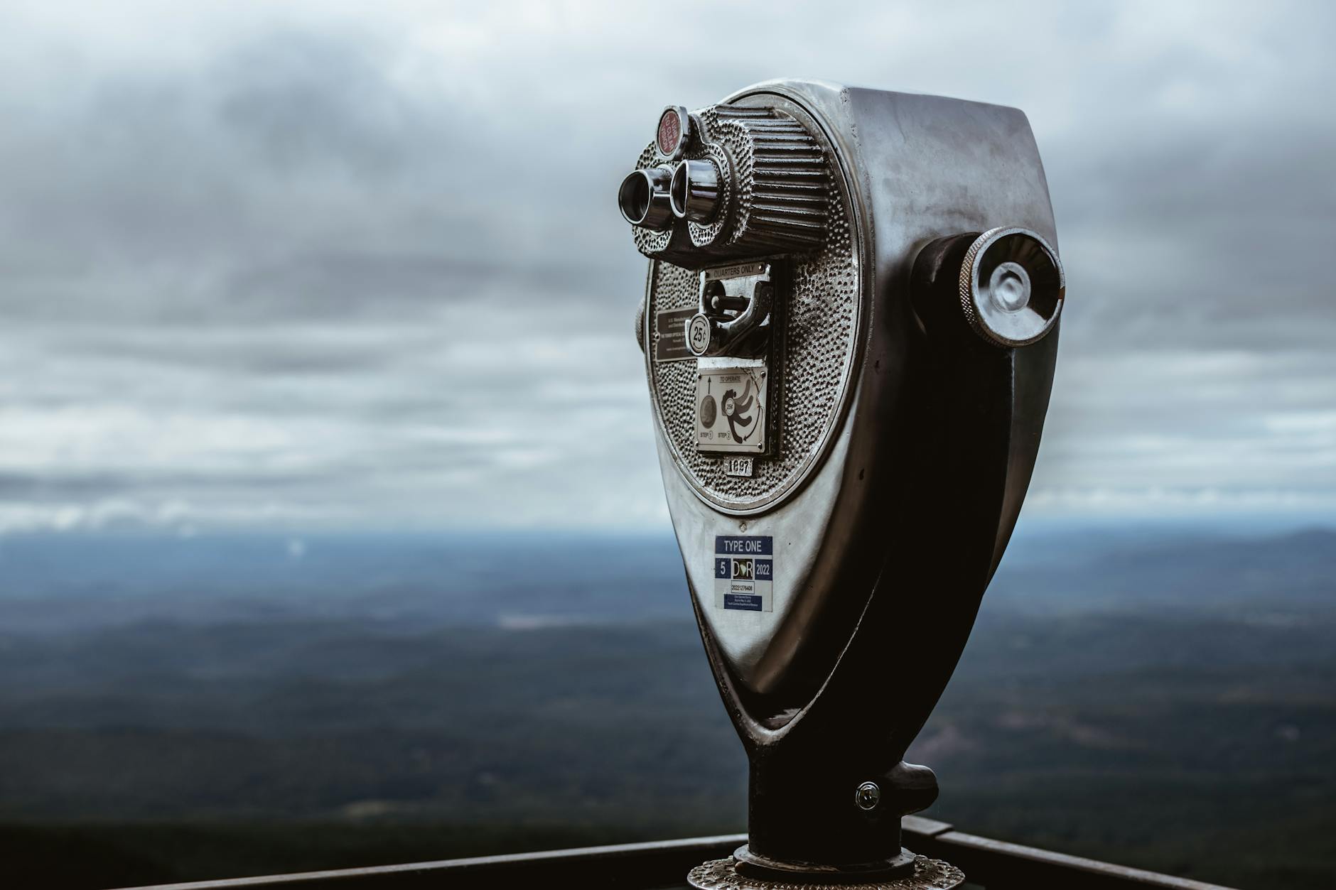 Moneta teleskop turystyczny na górze pod pochmurnym niebem