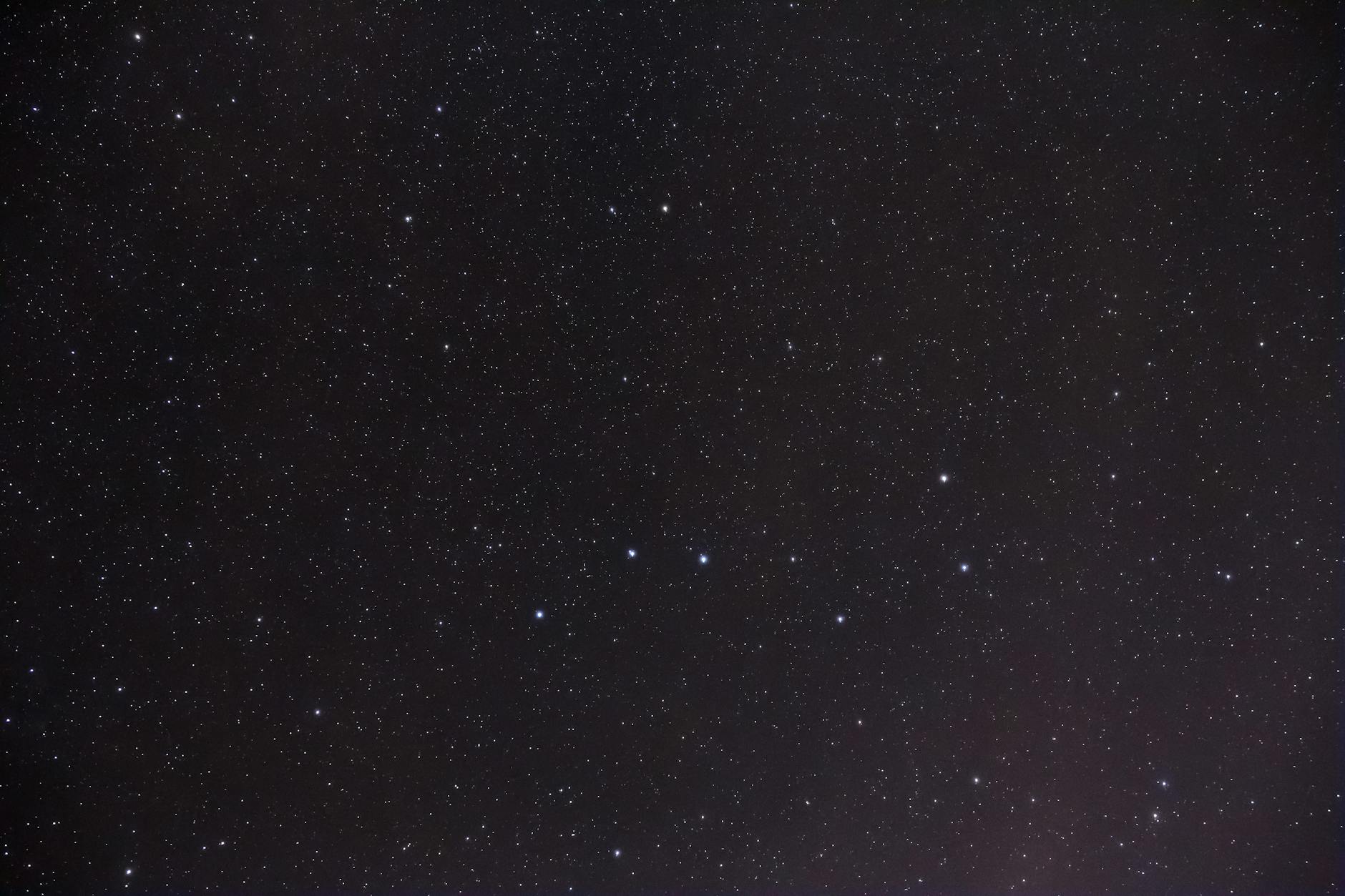 Rozgwieżdżone nocne niebo z wyraźnie widocznymi gwiazdozbiorami