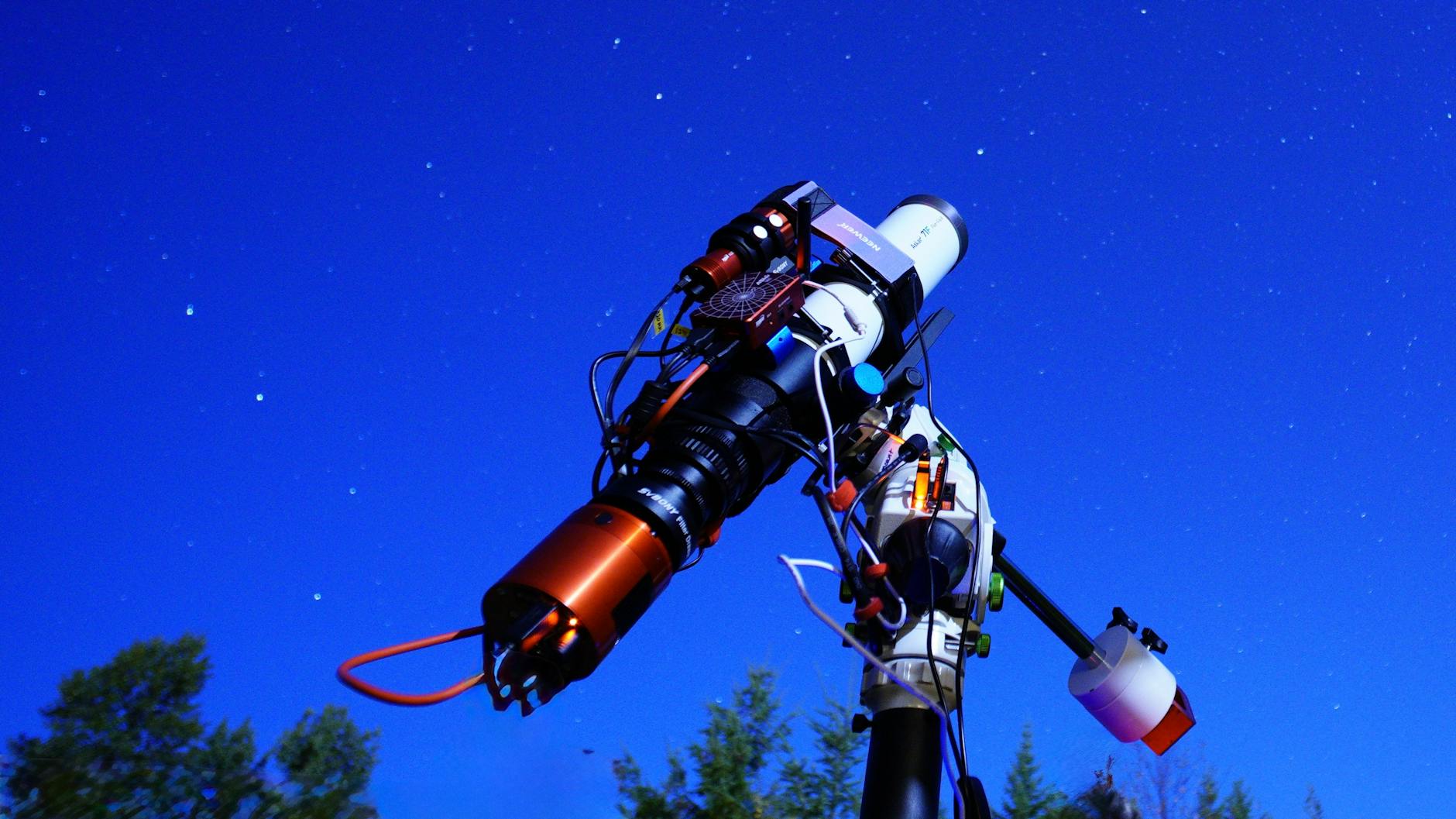 Teleskop skierowany w rozgwieżdżone nocne niebo podczas obserwacji