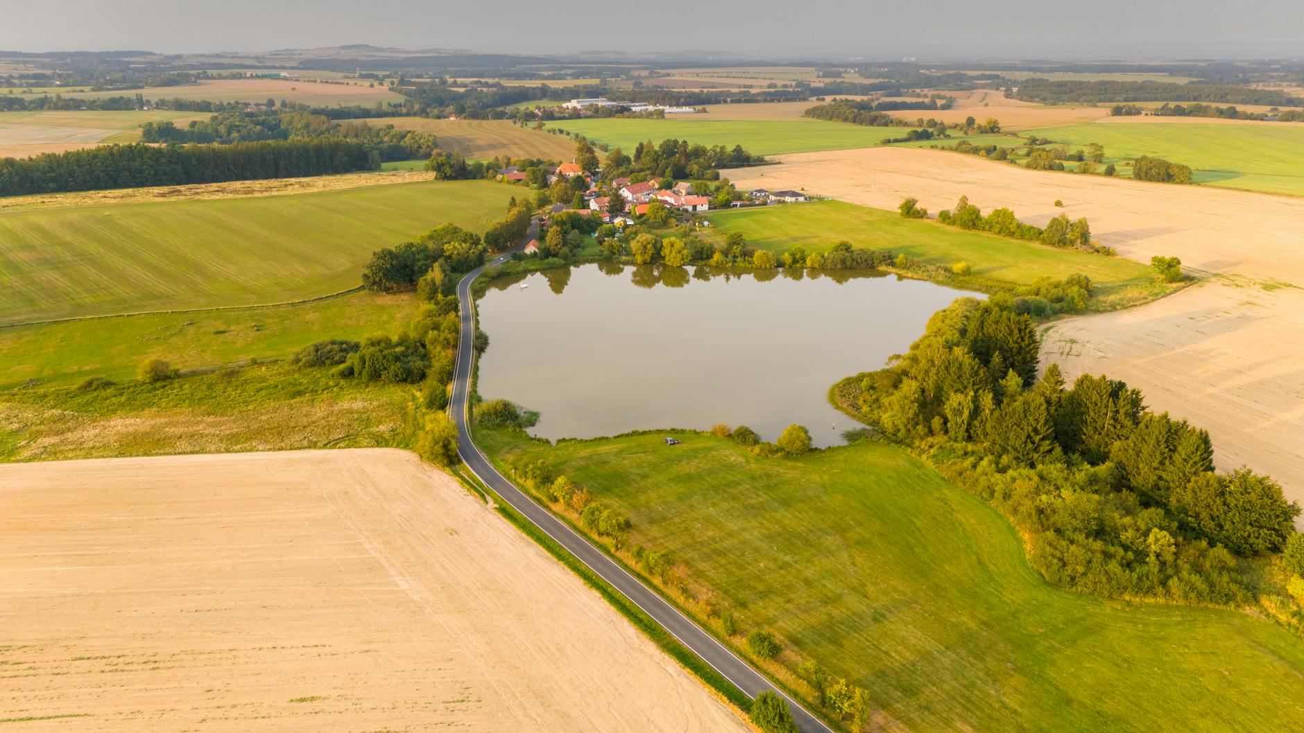 Widok z lotu ptaka na pola i jezioro w okolicach Zbraslavic w Czechach
