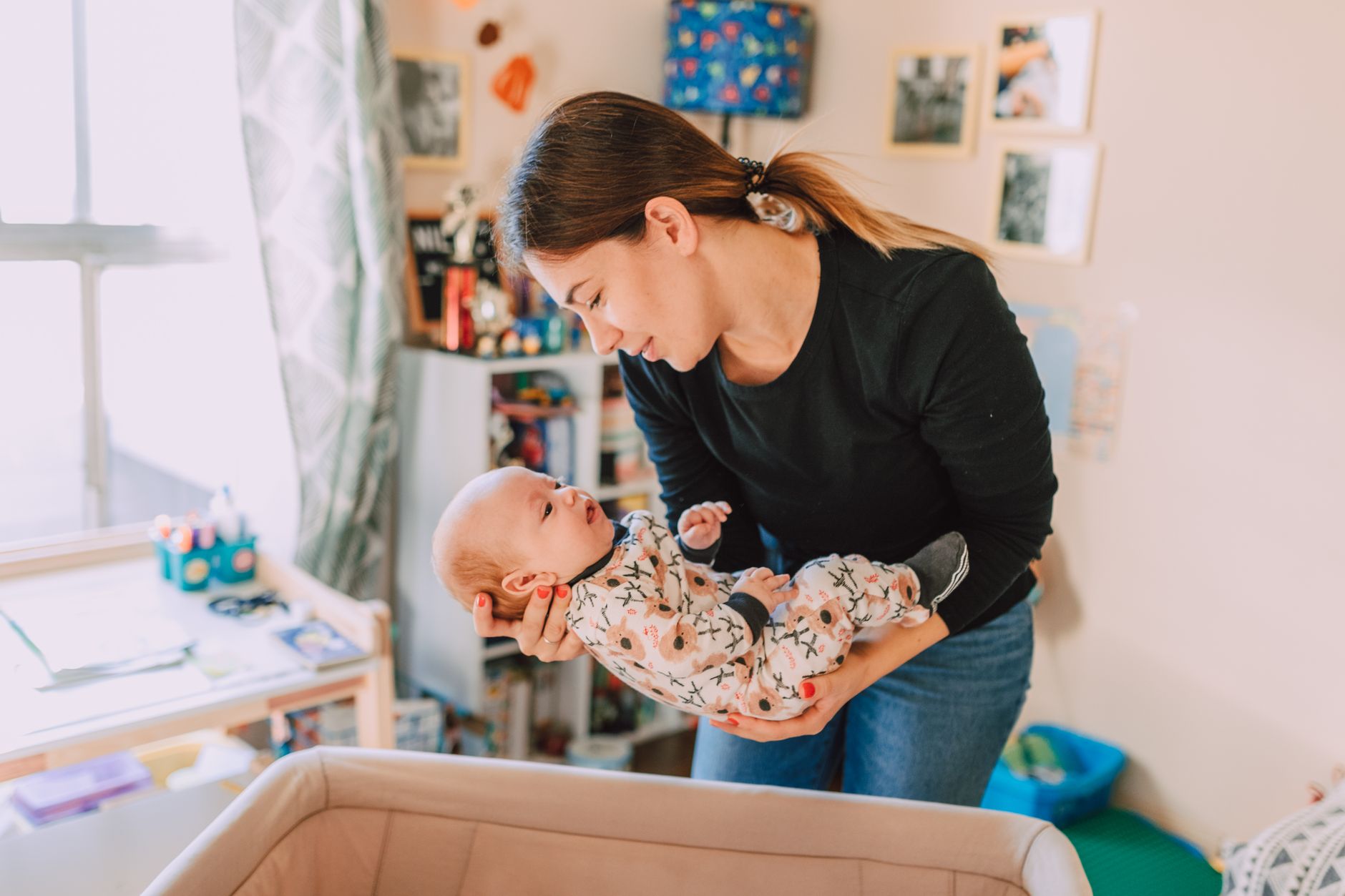 Mama tuląca noworodka w przytulnym pokoju niemowlęcym