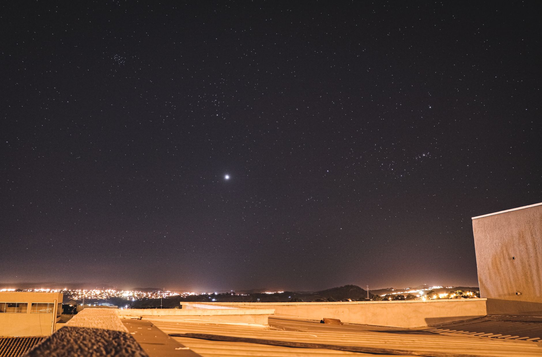 Nocne niebo pełne gwiazd nad miastem Goiânia oglądane z dachu