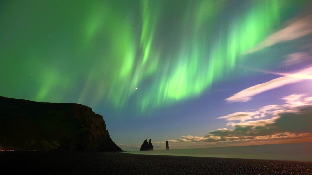 Zorza polarna nad skałami Reynisdrangar na Islandii