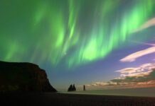 Zorza polarna nad skałami Reynisdrangar na Islandii